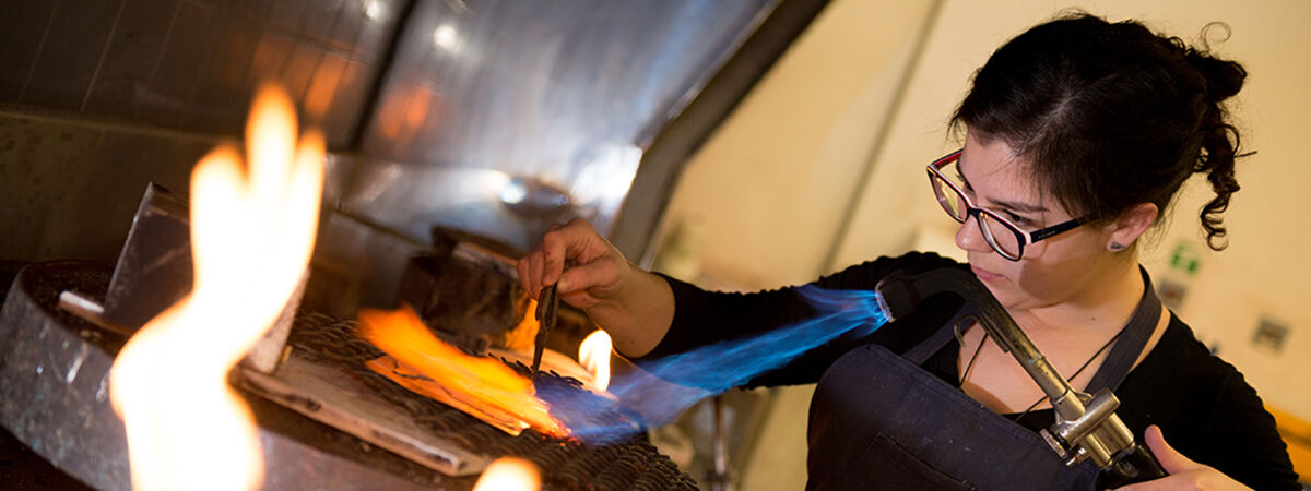 Student soldering jewellery with a blow torch.  