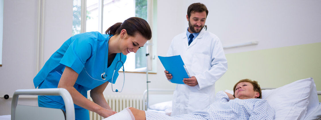 Nurse and Doctor attending to patient on bed.