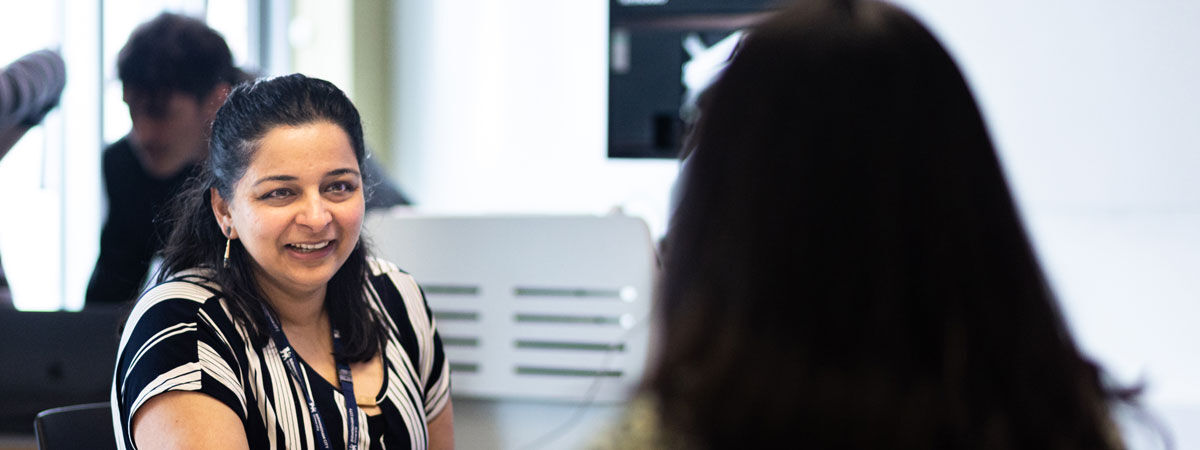 A postgraduate student works with others in a classroom