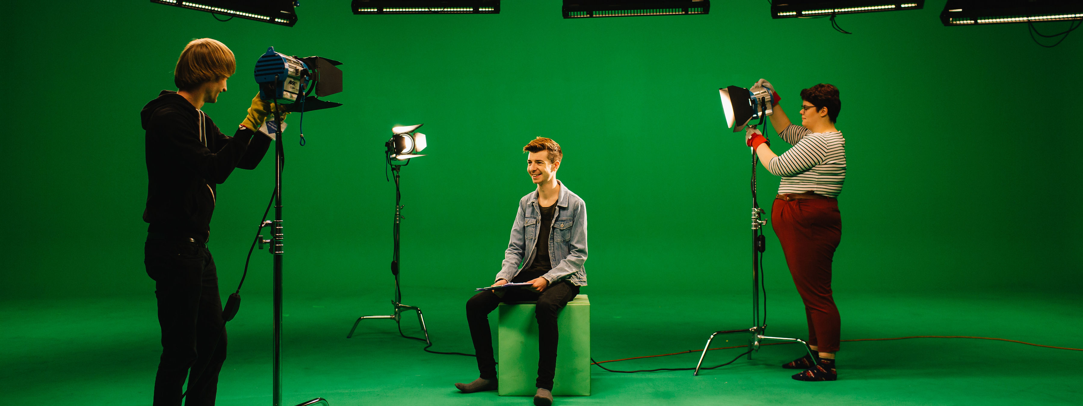 Three students in the green-screen studio