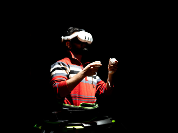 A man is playing on an omni-directional treadmill while wearing a VR headset